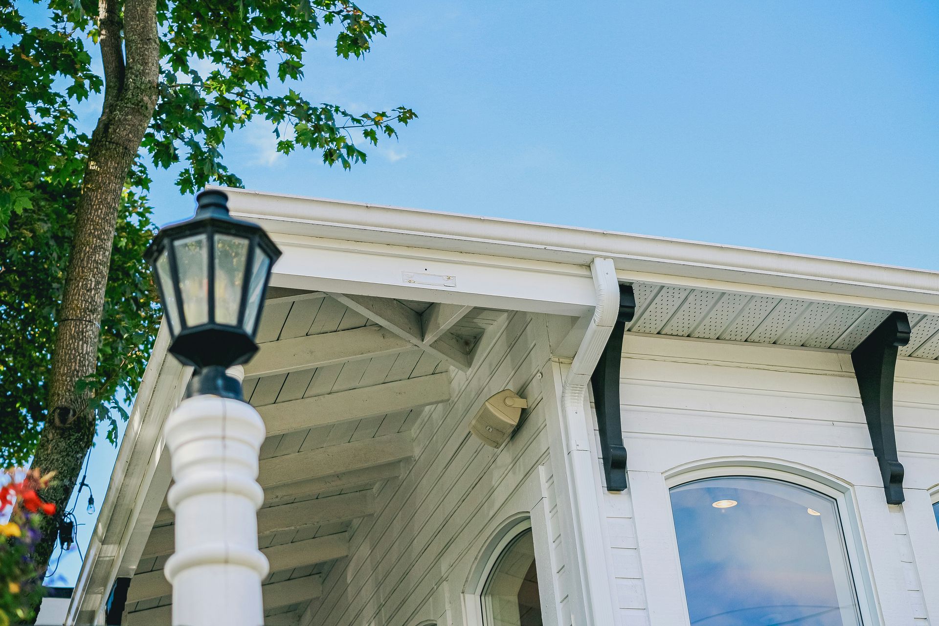 White building with black accents and a lamp post.